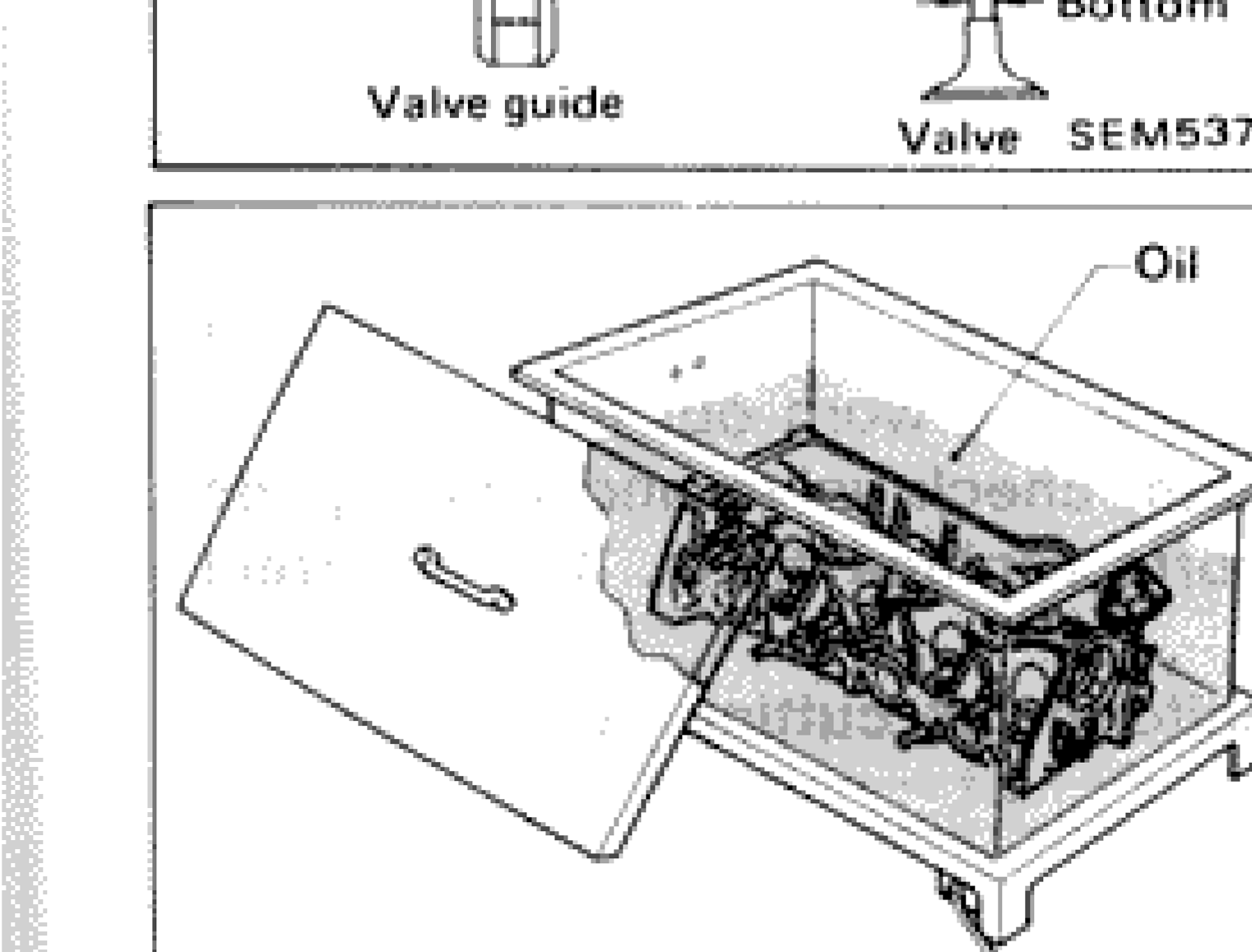 Cylinder head submerged in oil bath for heating during valve guide removal