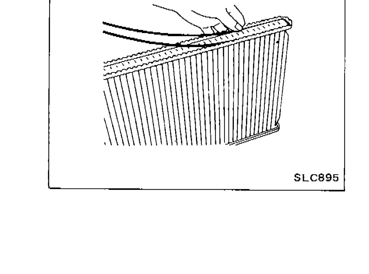 Hands pushing sealing rubber into the radiator tank with fingers