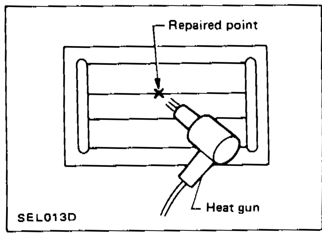 Diagram showing repaired point on rear window with heat gun being applied at a distance to cure the conductive silver composition.