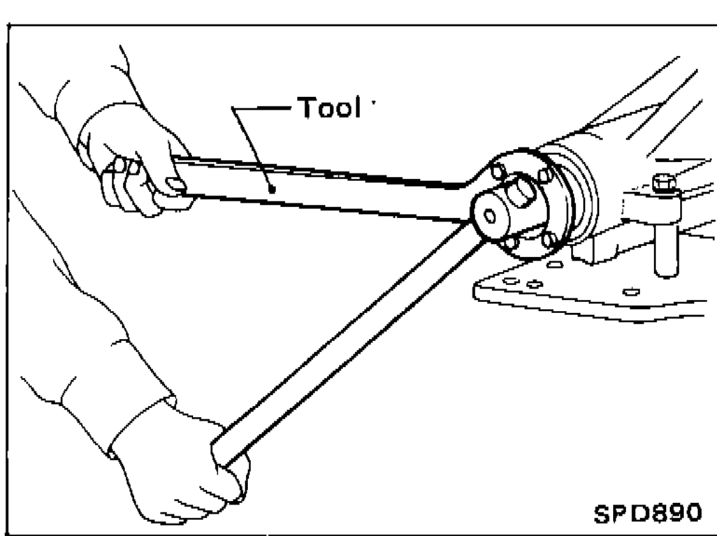 Technician loosening drive pinion nut using a tool and holding bar