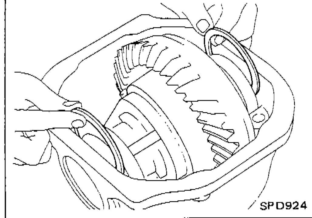 Inserting left and right side bearing adjusting washers between side bearings and carrier