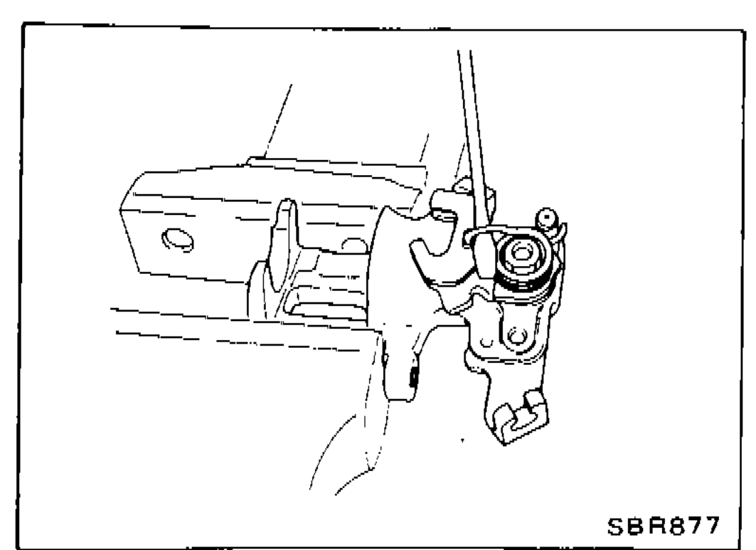 Rear caliper viewed from behind with hand removing the parking-lever return spring and lever.