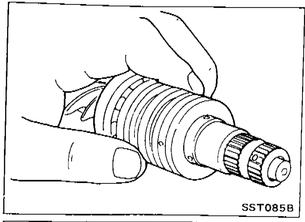 Pinion gear assembly in hand with the pinion seal ring being slid into its valve groove.